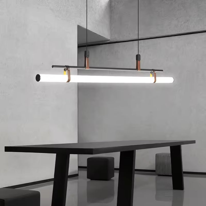 Suspension à tube LED, structure noire et attaches en cuir, dans un intérieur minimaliste contemporain