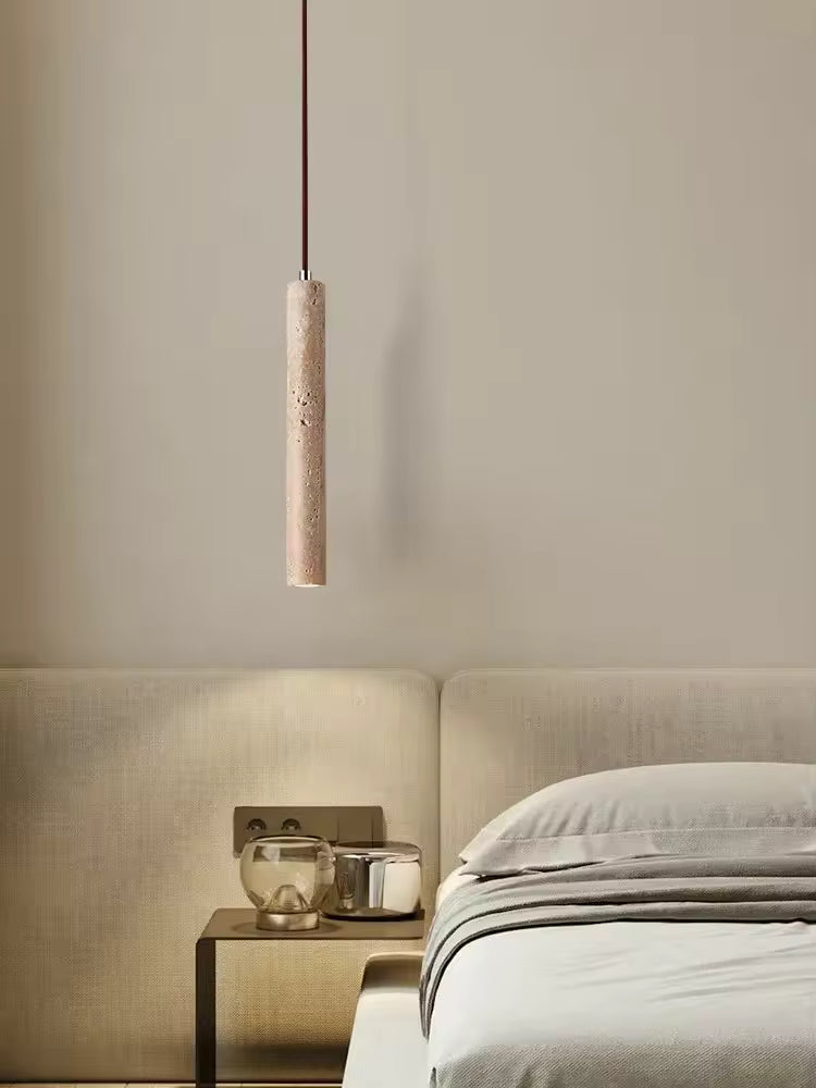 Luminaire suspendu en travertin près du lit dans une chambre contemporaine aux tons doux et minimalistes