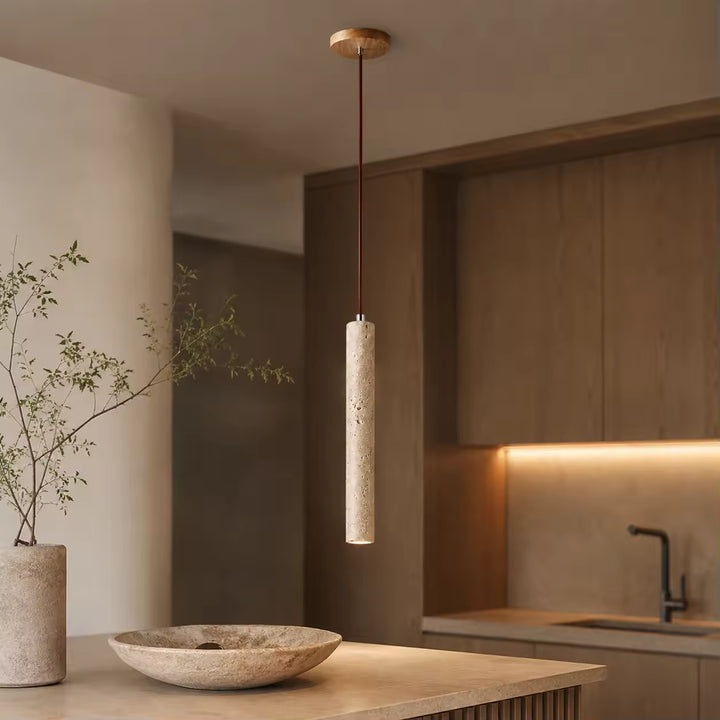 Suspension tube en travertin au-dessus d’un îlot de cuisine au style wabi-sabi et contemporain
