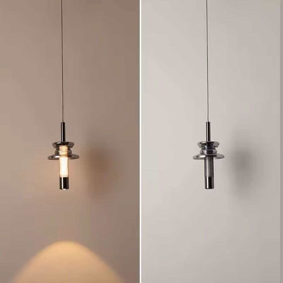 Allumée puis éteinte, cette suspension tubulaire en verre fumé révèle un éclairage chaud au design industriel