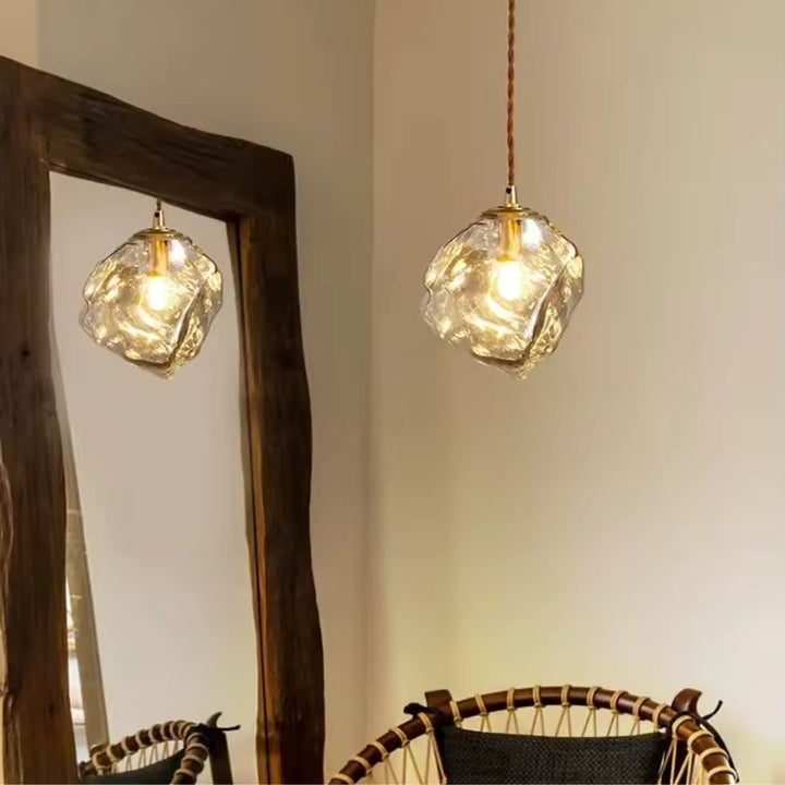 Dans une ambiance chaleureuse, cette suspension en verre ambré sculpté affirme un style organique et artisanal