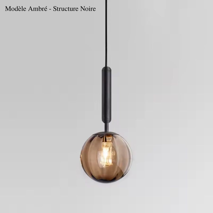 Globe en verre ambré suspendu à une structure noire élancée, pour une esthétique chaleureuse aux accents rétro