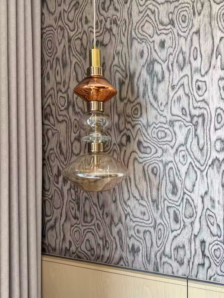 Élément suspendu en verre ambré et transparent aux volumes arrondis, dans un décor élégant d’inspiration vintage