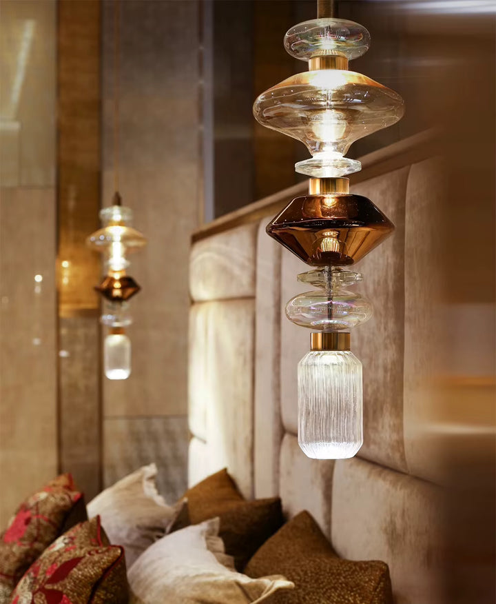 Dans une chambre élégante, le verre transparent et brun fumé compose un luminaire vertical aux accents Art déco