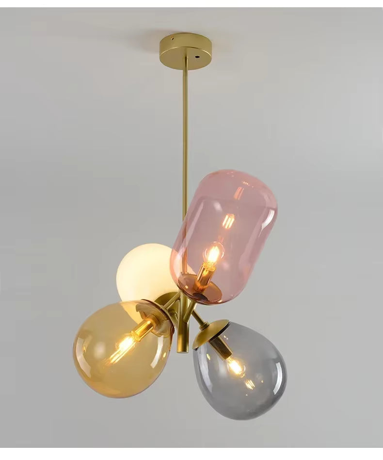Suspension vintage à globes en verre rose, ambre et fumé réunis en grappe autour d’une structure dorée