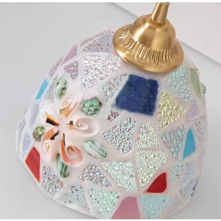 Détail d’une suspension en verre façonné façon mosaïque irisée, rehaussée de coquillages et d’une monture dorée