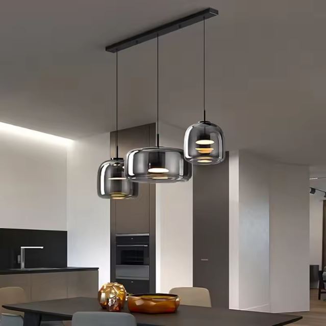Suspension verre fumé gris design idéale pour un îlot de cuisine moderne et épuré.
