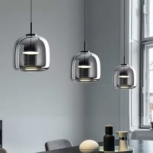 Trio de suspensions verre fumé gris au style contemporain, parfait pour éclairer une salle à manger avec élégance.