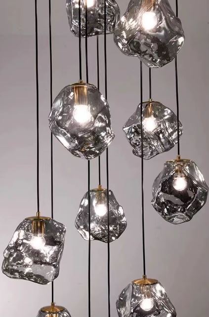 Suspension en verre fumé irrégulier, lustre cascade au style artistique et contemporain avec jeux de lumière raffinés.