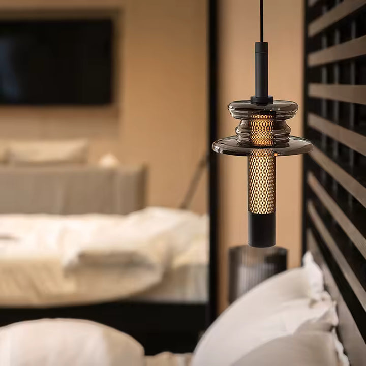 Dans une chambre feutrée, le verre fumé et le métal ajouré donnent à ce luminaire une allure contemporaine raffinée