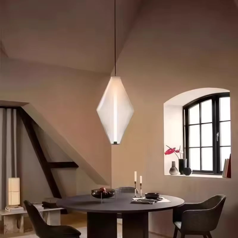 Éclairage suspendu en verre blanc facetté au style minimaliste, avec trait lumineux vertical au-dessus de la table