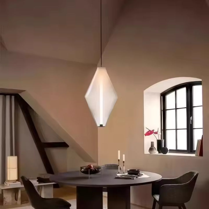 Éclairage suspendu en verre blanc facetté au style minimaliste, avec trait lumineux vertical au-dessus de la table