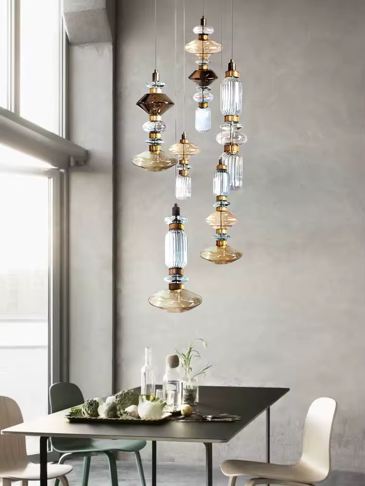 Dans la salle à manger, ce luminaire en verre aux volumes géométriques superposés affirme un style rétro contemporain