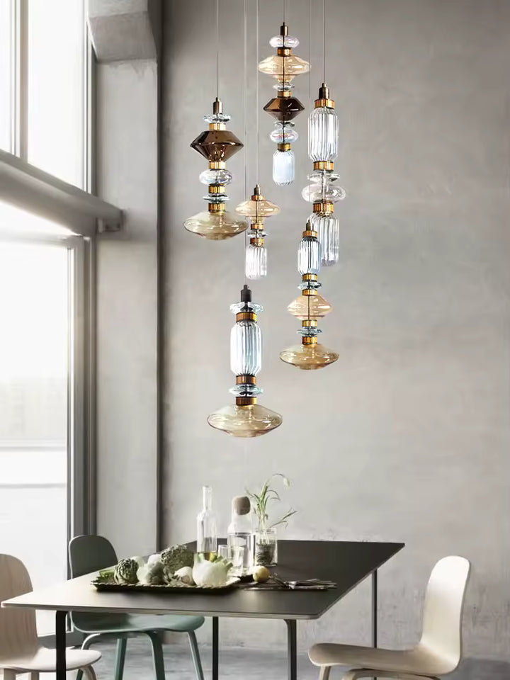 Dans la salle à manger, ce luminaire en verre aux volumes géométriques superposés affirme un style rétro contemporain