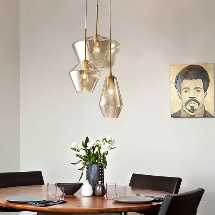 Suspension en verre géométrique et laiton au-dessus d’une table, au style design élégant et contemporain