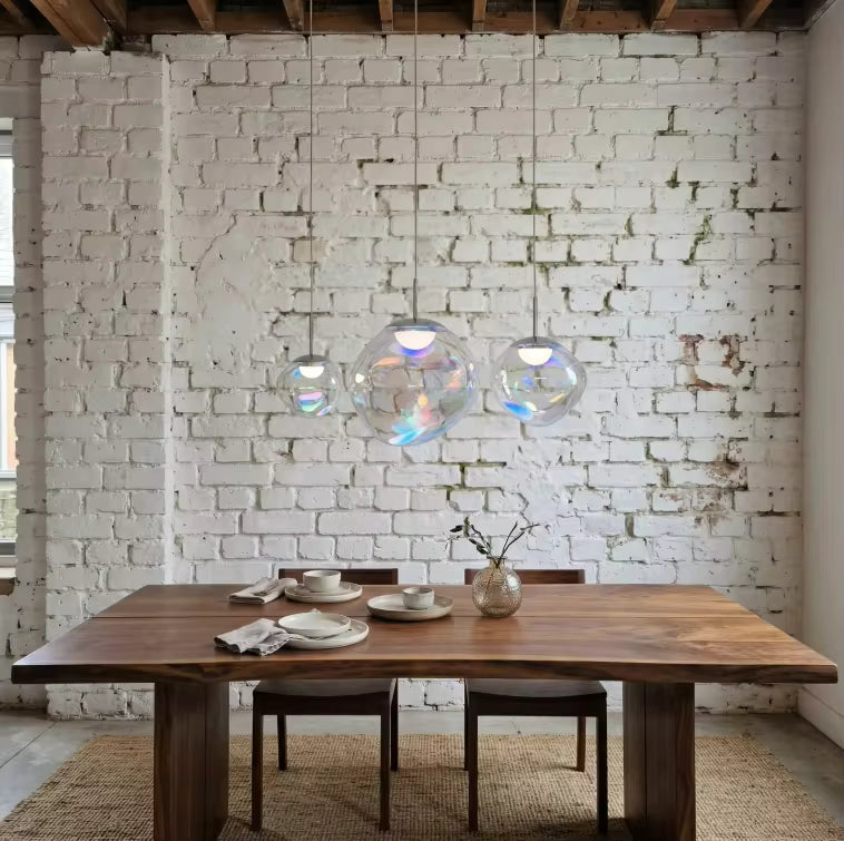 Suspension en verre irisé à trois globes, mise en scène dans une salle à manger au style industriel et chaleureux