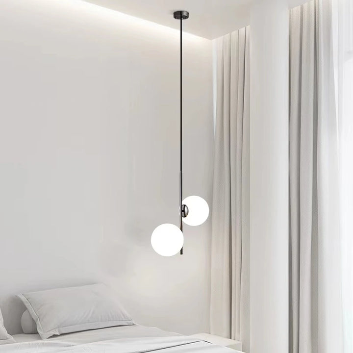 Suspension en verre diffusant une lumière douce dans une chambre au style japandi.