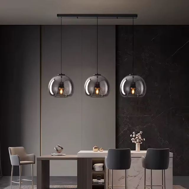 Suspension verre noir triple luminaire, parfaite pour une cuisine design ou un bar au style moderne et sophistiqué.