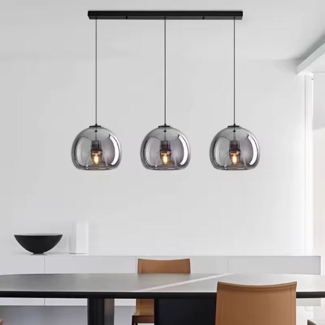 Suspension verre noir à trois lampes, design minimaliste et épuré, parfaite pour un intérieur contemporain lumineux.