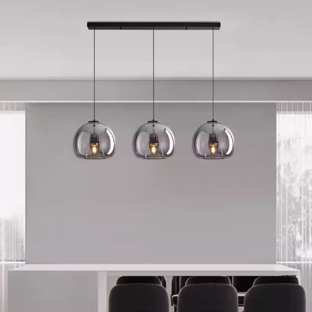 Suspension verre noir à trois lumières, idéale pour illuminer un espace repas ou un bar avec élégance contemporaine.