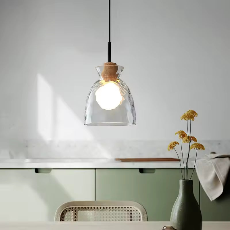 Suspension en verre ondulé et bois à forme cloche, installée dans une cuisine lumineuse au style scandinave