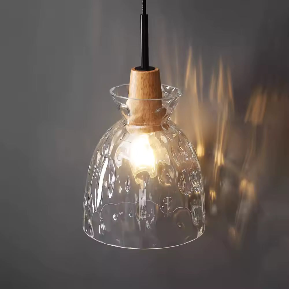 Suspension en verre ondulé et bois à forme cloche, diffusant une lumière chaude dans un esprit artisanal contemporain