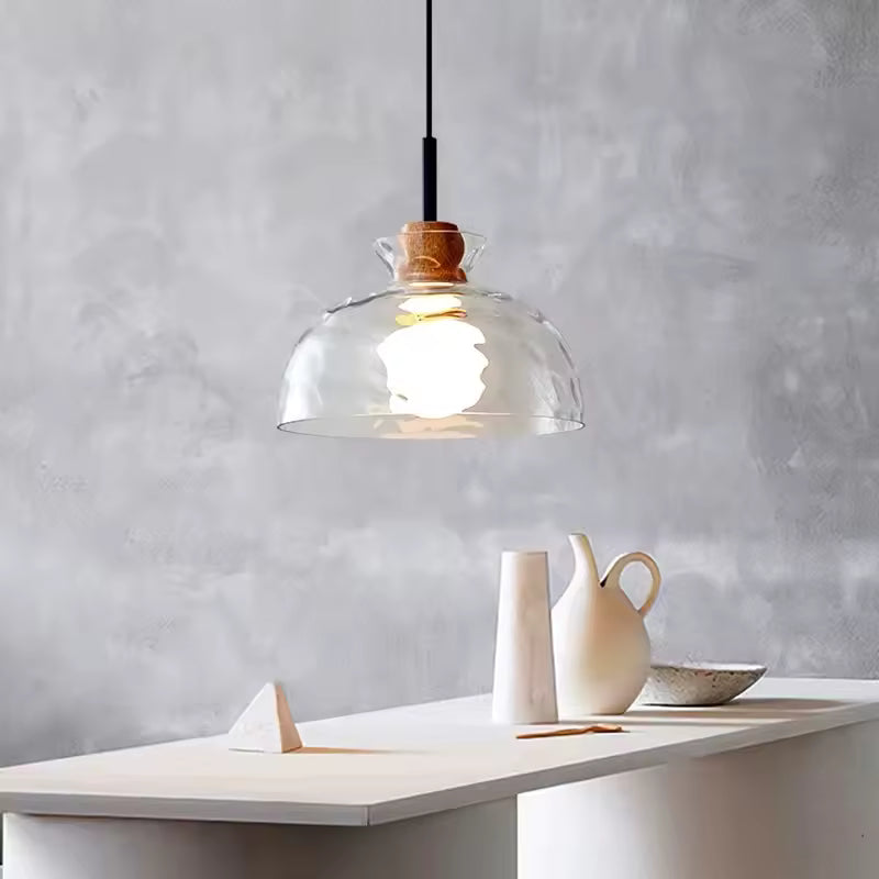 Suspension en verre ondulé et bois au-dessus d’une table, avec dôme transparent au style minimaliste chaleureux
