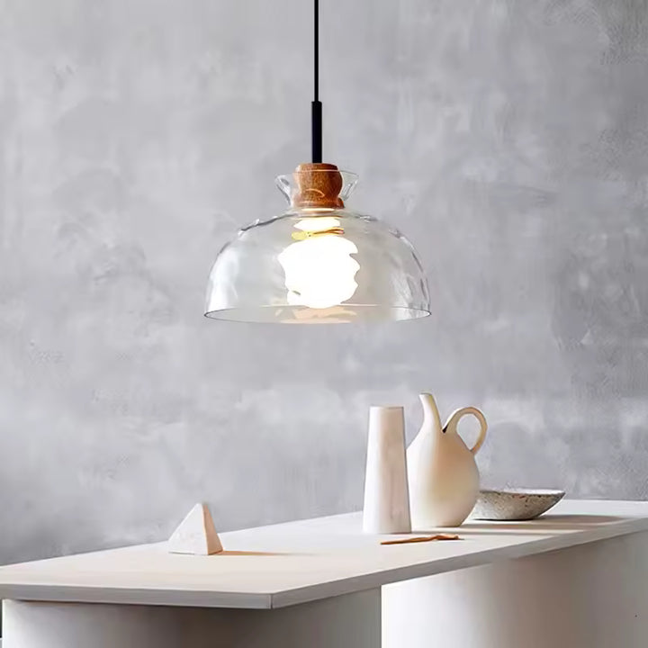 Suspension en verre ondulé et bois au-dessus d’une table, avec dôme transparent au style minimaliste chaleureux