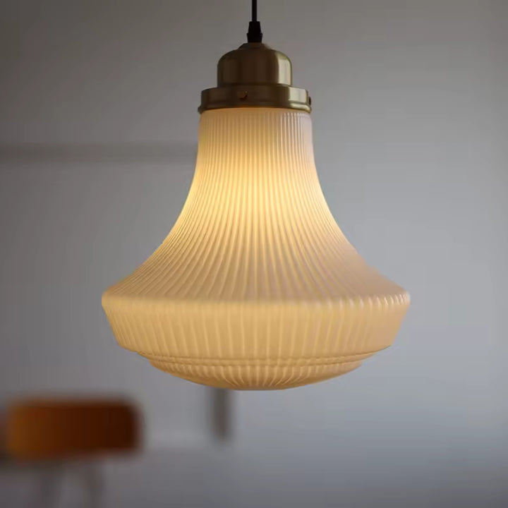 Luminaire en verre opalin nervuré à silhouette évasée, diffusant une lumière douce au charme vintage raffiné