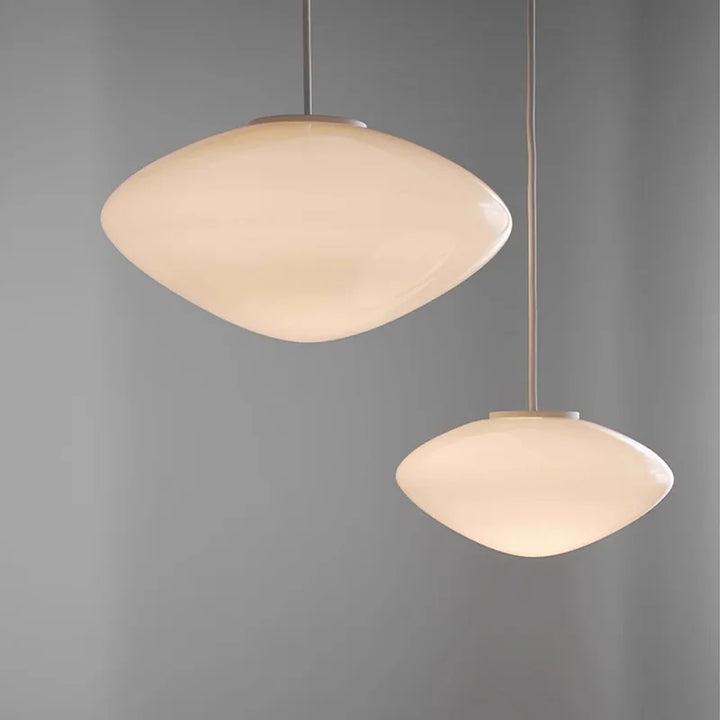 Suspension design en verre opalin blanc, idéale pour un éclairage doux et élégant au-dessus d'une table.
