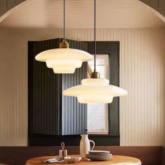 Duo de suspensions en verre opaline au style rétro, offrant une ambiance chaleureuse et lumineuse pour la salle à manger.