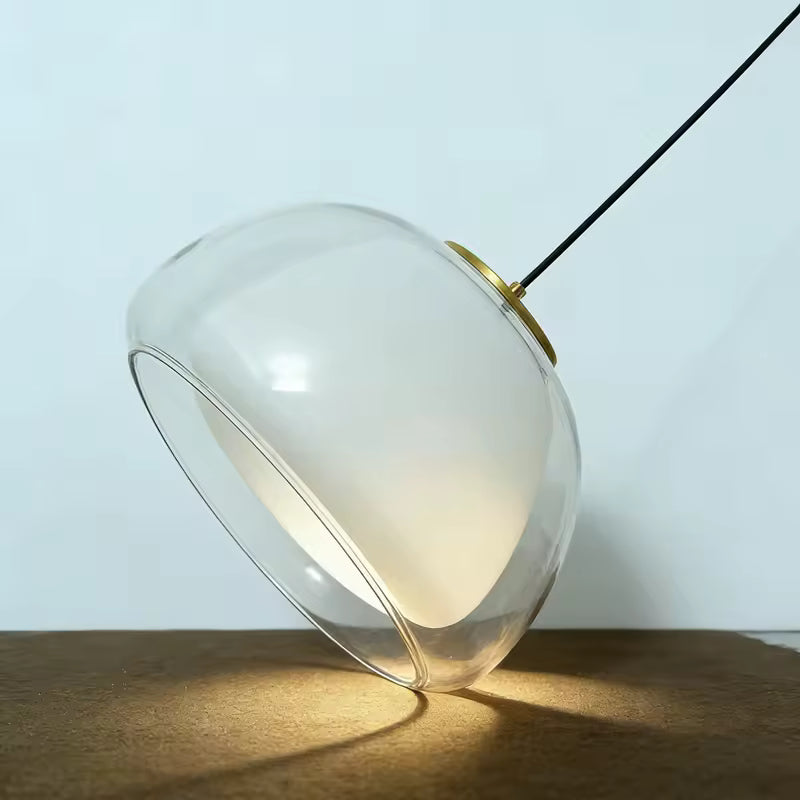 Suspension en verre transparent et cœur opalin vue de profil, avec silhouette sculpturale et finition dorée
