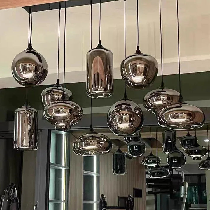 Gros plan sur une composition de luminaires suspendus en verre fumé au design moderne.