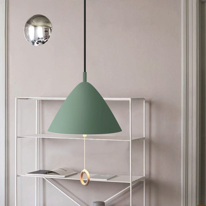 Suspension vert pastel mise en valeur dans un coin bureau avec étagère murale.