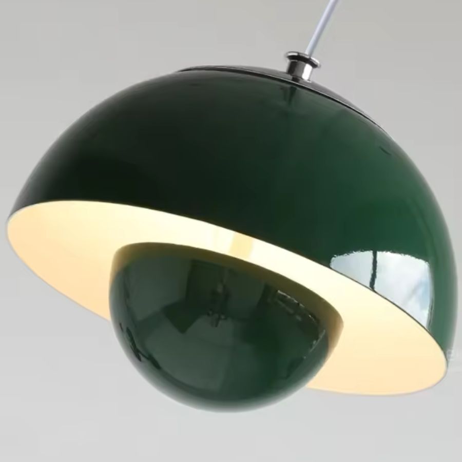 Vue rapprochée d’un luminaire suspendu vert profond à dôme et sphère, aux courbes rétro et à la finition brillante