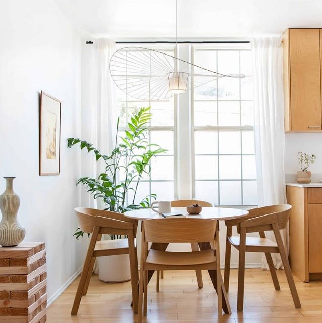 Suspension Vertigo blanche apportant une touche design minimaliste dans une salle à manger lumineuse avec table en bois.