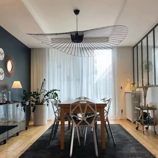 Suspension Vertigo noire, ajoutant une touche contemporaine et élégante à une salle à manger lumineuse et stylée.