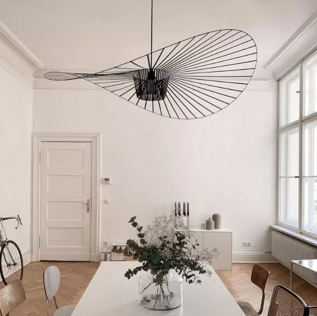 Suspension Vertigo noire, ajoutant une touche moderne et élégante dans une salle à manger lumineuse au style épuré.