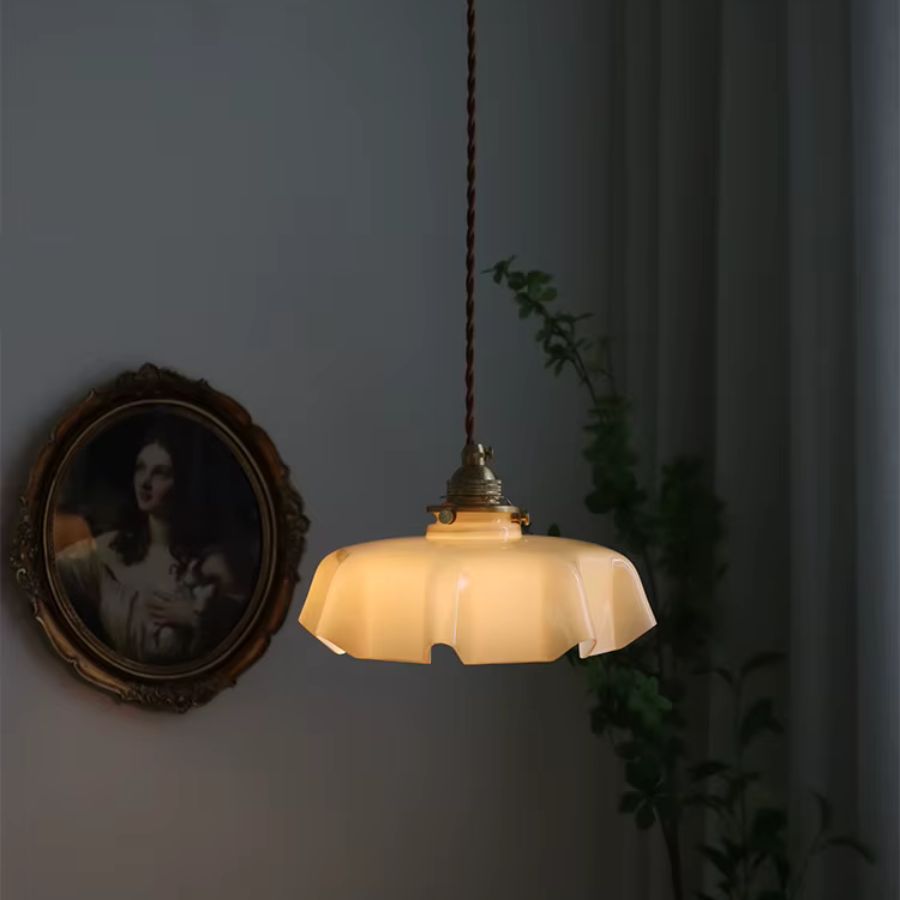 Suspension vintage à abat-jour festonné crème diffusant une lumière douce dans une ambiance rétro intimiste