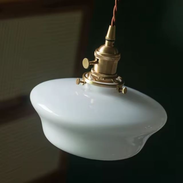 Vue rapprochée d'une suspension vintage en opaline blanche, un luminaire rétro idéal pour une ambiance élégante et intemporelle.