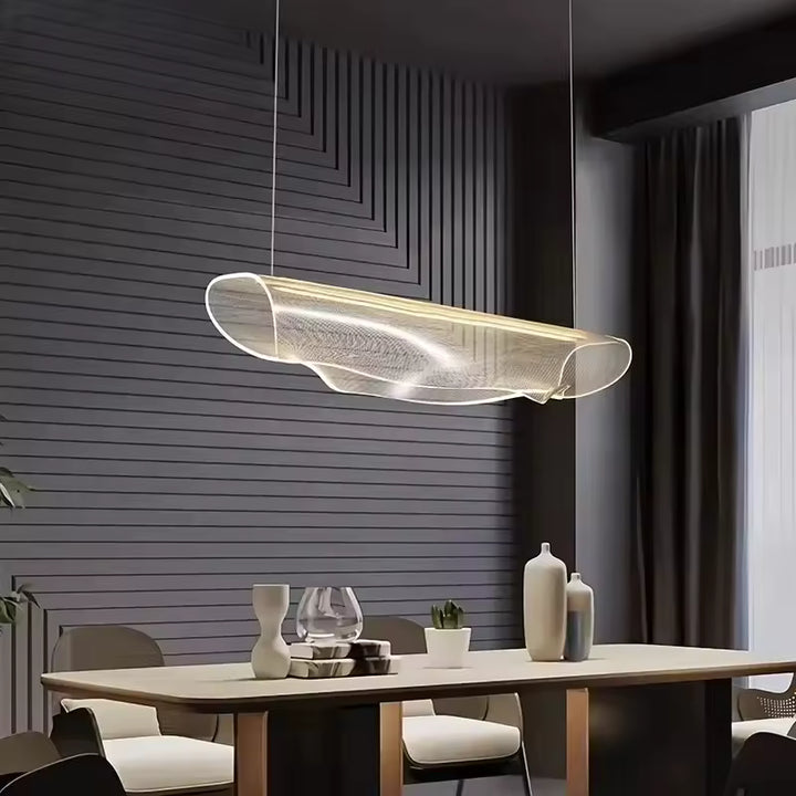 Suspension sculpturale en acrylique lumineux aux lignes fluides, dans une salle à manger contemporaine et épurée
