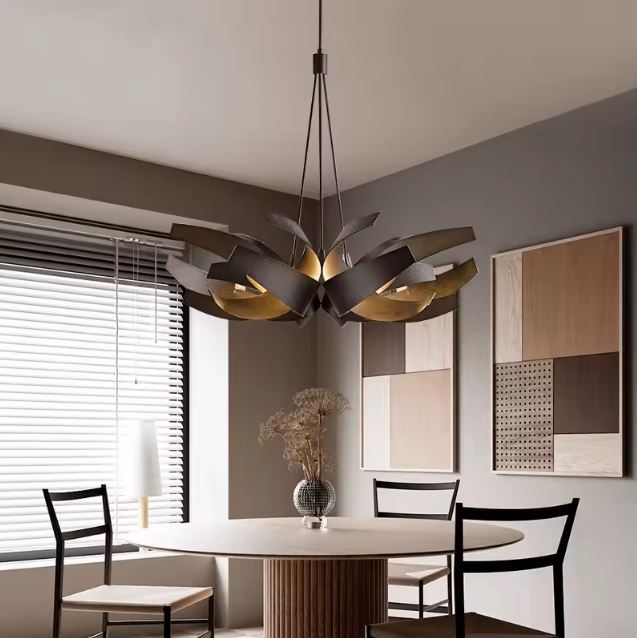 Suspension en volutes de métal entrelacées, au design sculptural et contemporain dans une salle à manger élégante.