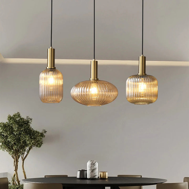 Suspension en verre cannele doree suspendue au-dessus d une table dans le salon, offrant un eclairage doux et une ambiance elegante pour un interieur moderne