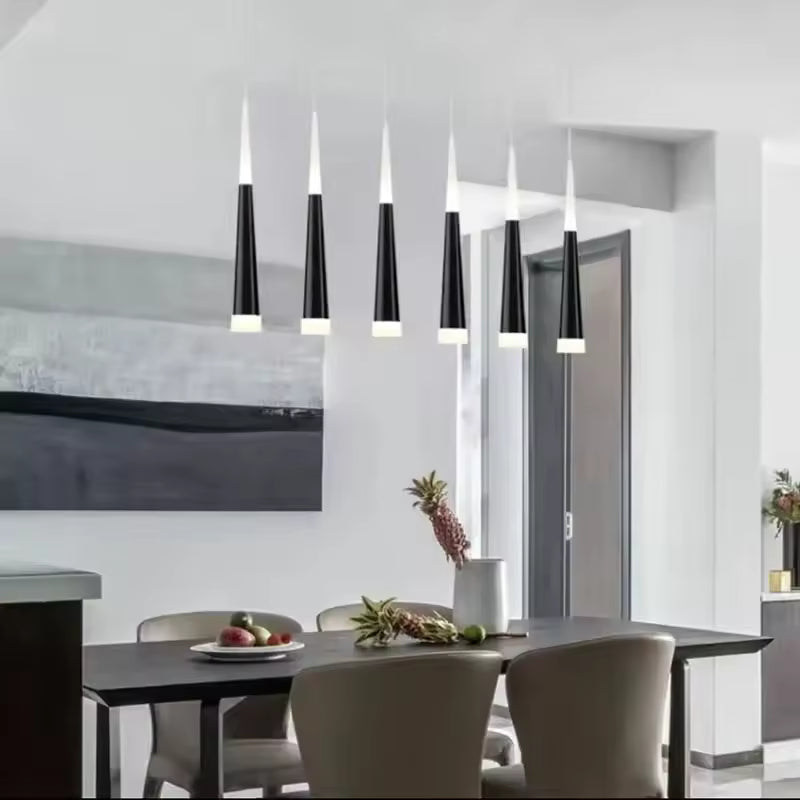 Alignement de suspensions aiguille LED noires au-dessus d’une table de salle à manger au style moderne épuré