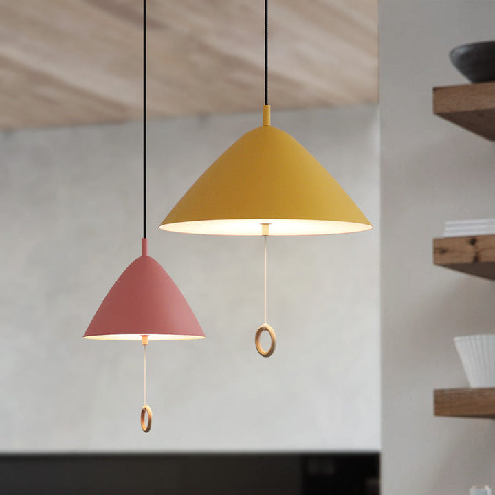 Suspensions colorées de style danois intégrées dans une cuisine ouverte chaleureuse.