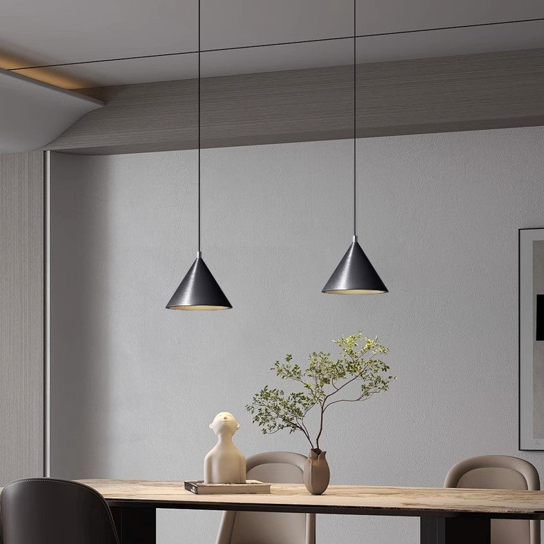 Duo de suspensions coniques en métal suspendues au-dessus d'une table de salle à manger, style moderne et épuré.