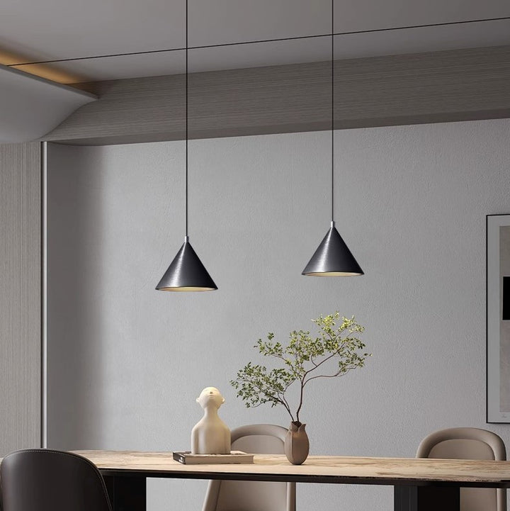 Duo de suspensions coniques en métal suspendues au-dessus d'une table de salle à manger, style moderne et épuré.