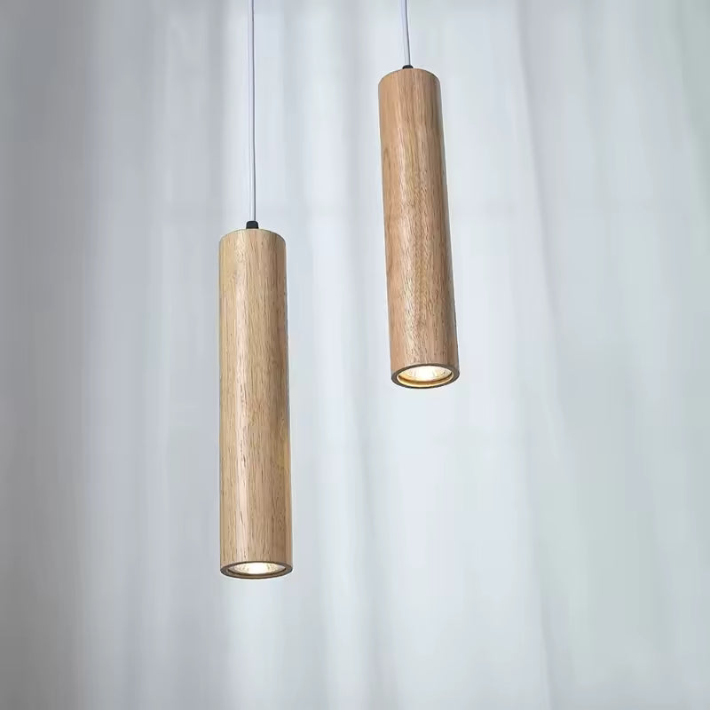Paire de suspensions cylindriques en bois clair au design japandi épuré, avec lumière dirigée vers le bas