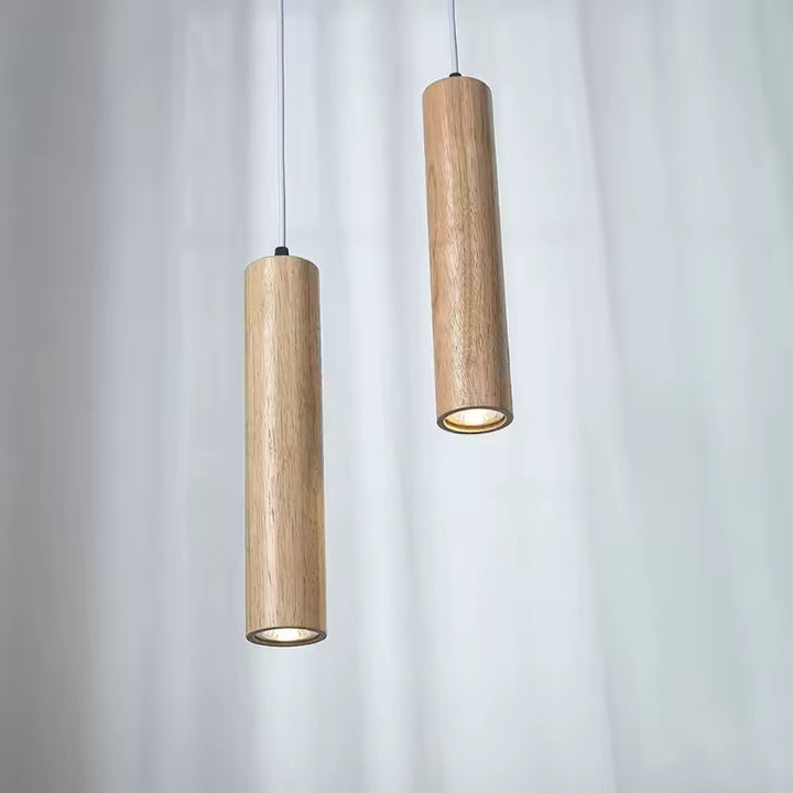 Paire de suspensions cylindriques en bois clair au design japandi épuré, avec lumière dirigée vers le bas