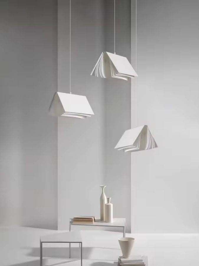 Trois suspensions design en forme de livre ouvert dans un décor blanc minimaliste à l’esprit sculptural contemporain